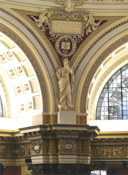 A statue of a woman in the center of an arch.